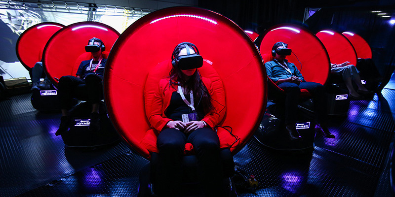 Multiple people sitting in Voyager VR pods, engaging in VR.