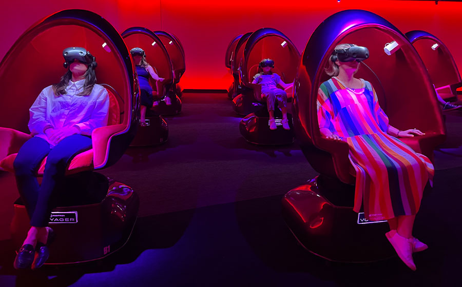 many people sitting in a red room in positron chairs