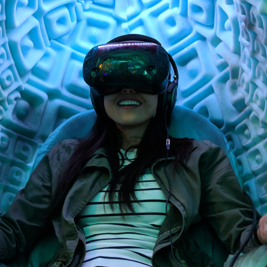 A smiling woman wearing a VR Headset.